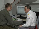 Ein Rotkreuz-Mitarbeiter informiert Oberstleutnant Breitfuss. (Bild öffnet sich in einem neuen Fenster)