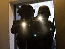 Militärpolizisten durchsuchen ein Gebäude. (Bild öffnet sich in einem neuen Fenster)