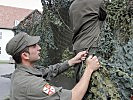 Soldaten tarnen eine Anlage. (Bild öffnet sich in einem neuen Fenster)