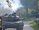 Zwei "Leopard"-Panzer bewegen sich vorsichtig in die Ortschaft. (Bild öffnet sich in einem neuen Fenster)
