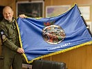 Oberst P. mit der Fahne der "Headquarters Support Group". (Bild öffnet sich in einem neuen Fenster)