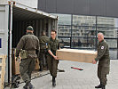 Österreichische Soldaten helfen bei der Entladung des Containers. (Bild öffnet sich in einem neuen Fenster)