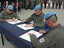 Die Kommandanten unterzeichnen die Übergabe-Dokumente. (Bild öffnet sich in einem neuen Fenster)