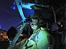 A helicopter pilot gets ready for a night sortie. (Image opens in new window)