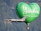A Eurofighter jet in front of a Styrian hot-air balloon.