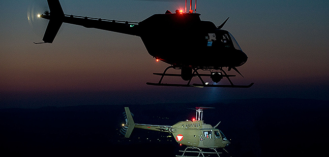 Two helicopters during a night flight.