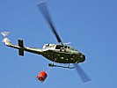 Eine Agusta Bell 212 beim Transport eines Wasserbehälters. (Bild öffnet sich in einem neuen Fenster)