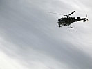 Ein gefährdeter Hang wird vom Helikopter aus begutachtet. (Bild öffnet sich in einem neuen Fenster)