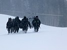 Die abgesessenen Soldaten kämpfen sich im Schnee zur Unfallstelle vor. (Bild öffnet sich in einem neuen Fenster)