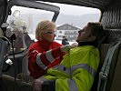 Eine Rot-Kreuz-Mitarbeiterin sichtet einen Verletzten im Hubschrauber. (Bild öffnet sich in einem neuen Fenster)