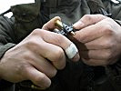 Ein Schütze befüllt einen MG-Gurt mit Munition. (Bild öffnet sich in einem neuen Fenster)