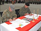 Die Bataillonskommandanten unterzeichnen die Partnerschaftsurkunden.