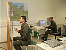 Die Soldaten stimmen ihre Beurteilungen an der Landkarte mit dem Simulationssystem am Computer ab.