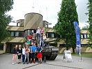 Besucher posieren rund um einen Kampfpanzer "Leopard".