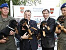 Minister Darabos und LH Niessl mit Hundeführern und den Welpen.