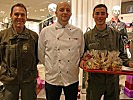 Major Spari, der Küchenchef und Rekrut Schilling präsentieren die Kekse.