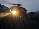 Ein S-70 "Black Hawk" landet mit Evakuierten an Bord im Tal.