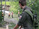 Sanitäter des Österreichischen Bundesheeres überwachen die gefährlichen Arbeiten der Soldaten.