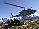 Rekruten werden im alpinen Gelände von einem Hubschrauber abgesetzt.