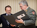 Generalleutnant Christian Segur-Cabanac und Heinz Derfler, Vizepräsident des Schwarzen Kreuzes, begutachten die Bücher.