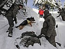 In Zusammenarbeit mit einem Lawinensuchhund der Bergrettung wird ein Verletzten-Darsteller gefunden.