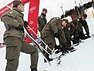 Bundesheer-Soldaten beim Anlegen von Steigeisen für die steile WM-Piste.