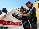 Der 20-jährigen Maturantin Lucia aus Innsbruck wird das Einsatzmotorrad der Militärstreife von Stabswachtmeister Karin Pirschner erklärt.