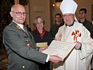 Der Militärbischof überreicht das päpstliche Ordensdekret an den Ausgezeichneten.