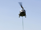 Ein Agusta Bell 212 beim Transport von Einsatzgerät für die Einsatzkräfte.