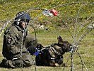 Der Hundeführer der Militärpolizei bereitet den Hund für den Einsatz vor.