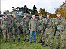 Der Minister und die Besatzung eines Schützenpanzers der deutschen Bundeswehr.