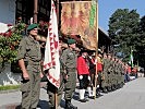 Die Fahne des Militärkommandos Tirol und die Tiroler Landesstandarte stehen an der Spitze der Ehrenformation.