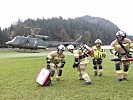 Feuerwehrmänner mit Spezialgeräten werden durch einen Hubschrauber in den Einsatzraum gebracht.