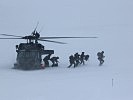 Die ersten ERTA-Spezialisten sitzen im tiefen Schnee von einem S-70 "Black Hawk" ab.