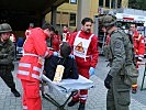 Ein Verletzter wird an das Rote Kreuz übergeben.