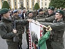 Die Rekruten legen ihre Hand an die Fahne des Militärkommandos Oberösterreich.