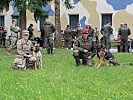 Militärhundeführer und ihre Diensthunde aus den USA (l.) und Österreich (r).