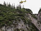 Ein Hubschrauber des ÖAMTC beim Anflug zur Bergung eines Verletzten in steilem Gelände.