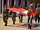 Drei Unteroffiziere des Militärkommandos Tirol und drei Schützen der Schützenkompanie Wilten tragen die Bundesdienstflagge.