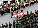 Die Bundesflagge wird gemeinsam von Soldaten und der Dorfjugend getragen.