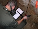 ABC-Abwehr-Spezialist bei Messungsarbeiten im Inneren der Polizeiinspektion.