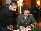 Militärdekan Rachlè signiert das persönliche Exemplar von Andreas Niesswohl.