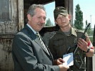 Landesrat Viktor Sigl übergit dem Wachsoldaten Richard Arnolder eine Telefonkarte.