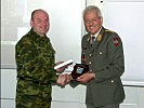 Oberst Travnikov (l.) überreicht Generalmajor Bair ein Geschenk der Militärattachés.