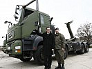 Minister Darabos und Oberst Gutmann vor einem der Lkw mit Hakenladesystem.