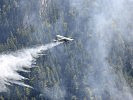 Eine Pilatus PC-6 lässt Wasser über dem Brand ab.