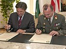 LH Voves und Militärkommandant Zöllner unterzeichnen eine Urkunde zur Erneuerung der Partnerschaft.