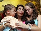 Sichtlich erleichtert schließt diese Mutter ihre Kinder am Flughafen Wien in den Arm.