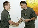 Oberst Pritz überreicht das Beförderungsdekret an einen der Soldaten.