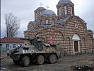 Ein österreichischer Radpanzer "Pandur" vor einer serbisch-orthodoxen Kirche.